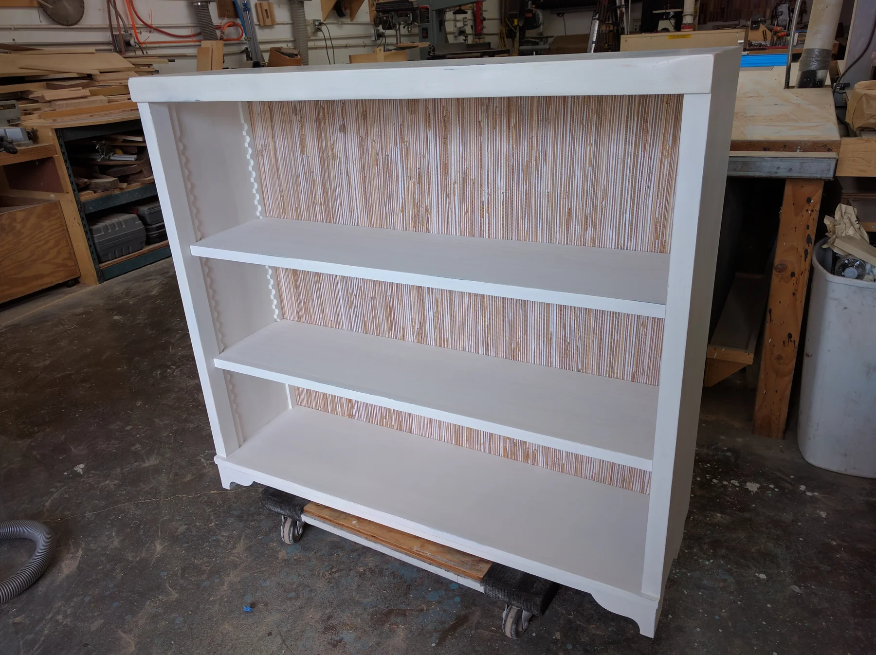 Finished painted bookcase fitted beside a bed